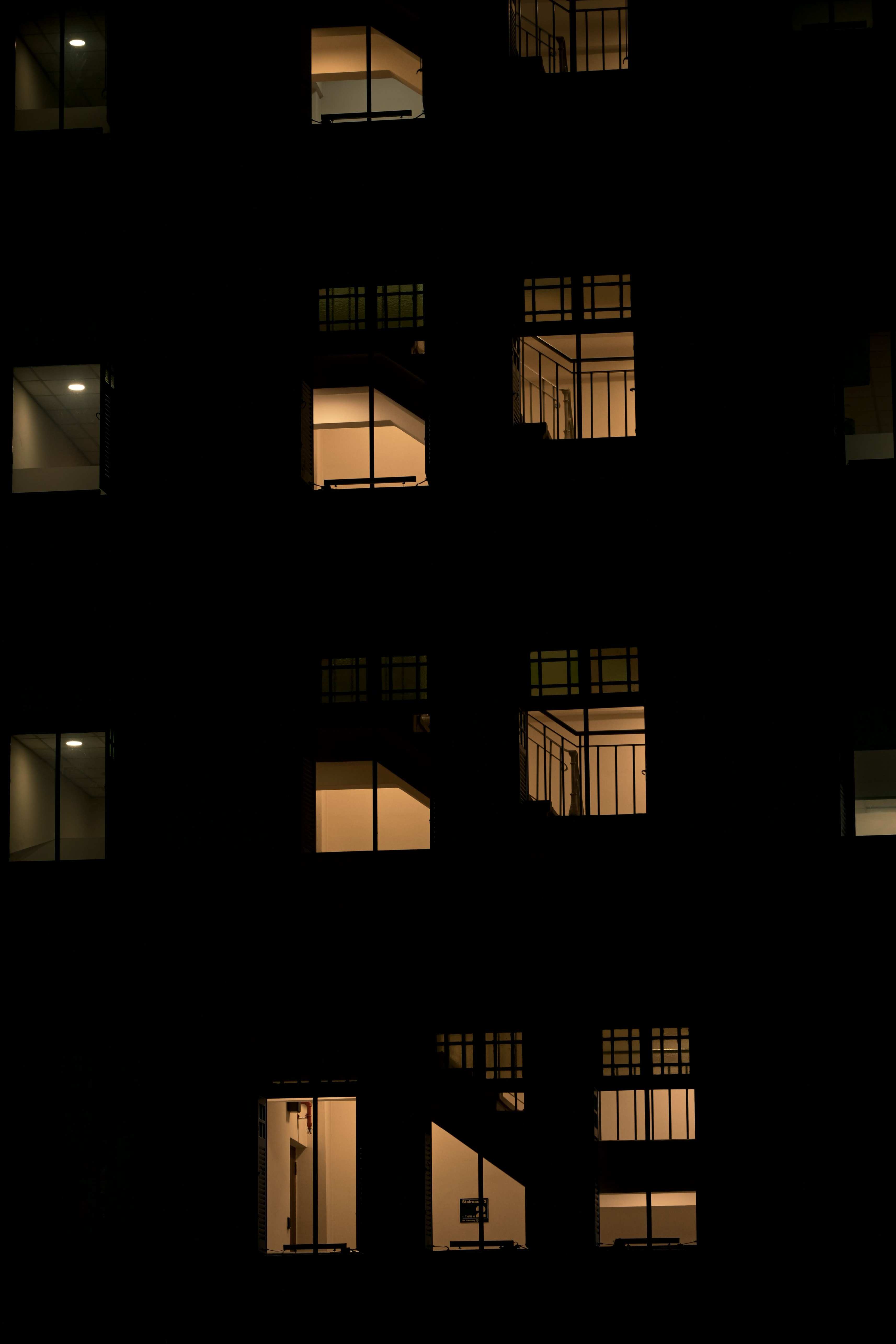 Office building exterior at night with lit windows along an urban skyline
